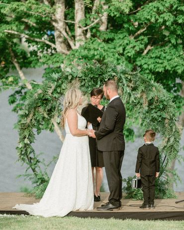 Bride, groom, Justice of Peace and small ring bearer getting married beside a lake in Nova Scotia.