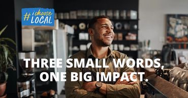 Man smiling in a cafe with text promoting local support.