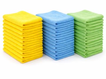 Three separate stacks of reusable microfiber cleaning cloths in bright yellow, blue, and green.