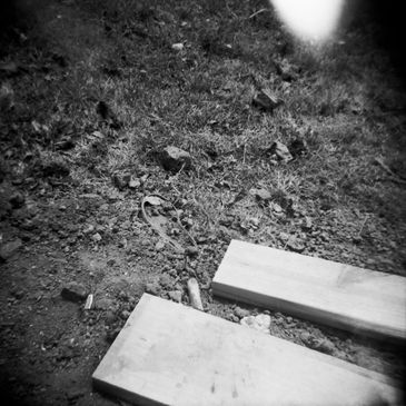 Black and white image of concrete steps with dirt and grass.