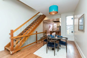Modern dining area with wooden stairs and blue accents.