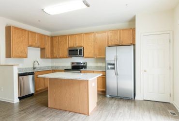 Modern kitchen with wooden cabinets and stainless steel appliances.