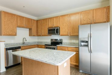 Modern kitchen with granite countertops and stainless steel appliances.