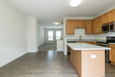 Empty modern kitchen with wood cabinets and island.