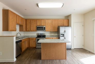 Modern kitchen with wooden cabinets and stainless steel appliances.