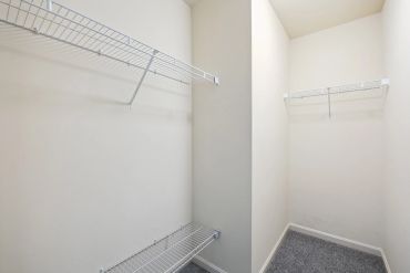 Empty walk-in closet with wire shelves.