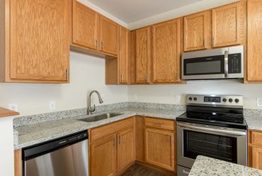 Modern kitchen with wooden cabinets and stainless steel appliances.