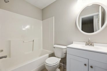 Minimalist white bathroom with bathtub and vanity.