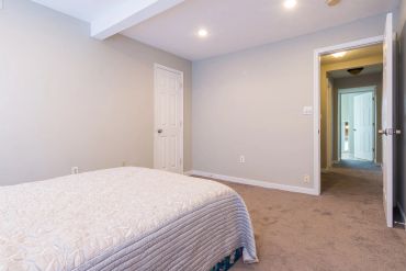 Empty bedroom with beige walls and carpet.