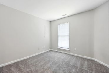 Empty room with gray carpet and white walls.