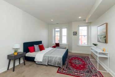 Modern bedroom with blue bed and red accents.