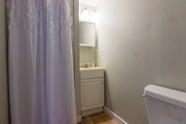Simple bathroom with shower curtain and sink.