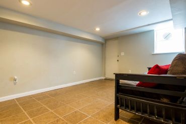 Minimalist room with a couch and tiled floor.