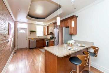 Modern kitchen with wooden cabinets and island seating.