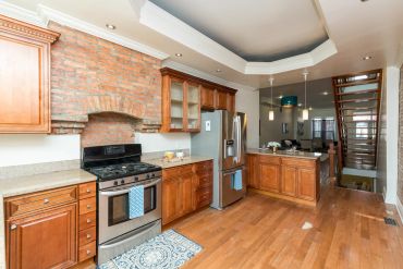 Spacious kitchen with wooden cabinets and stainless steel appliances.