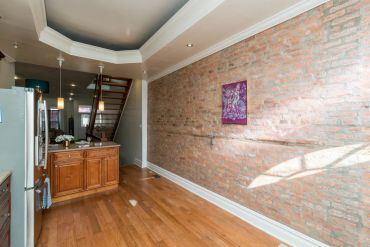 Cozy kitchen area with exposed brick wall and wooden floor.