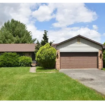 Suburban house with garage and green lawn.