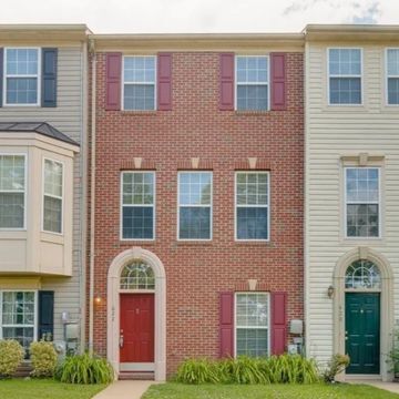Three attached houses with brick and siding exteriors.