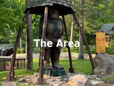 Sasquatch statue under a wooden shelter.