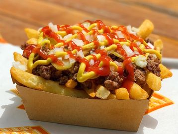 Loaded fries with ground beef, onions, pickles, mustard, and ketchup.