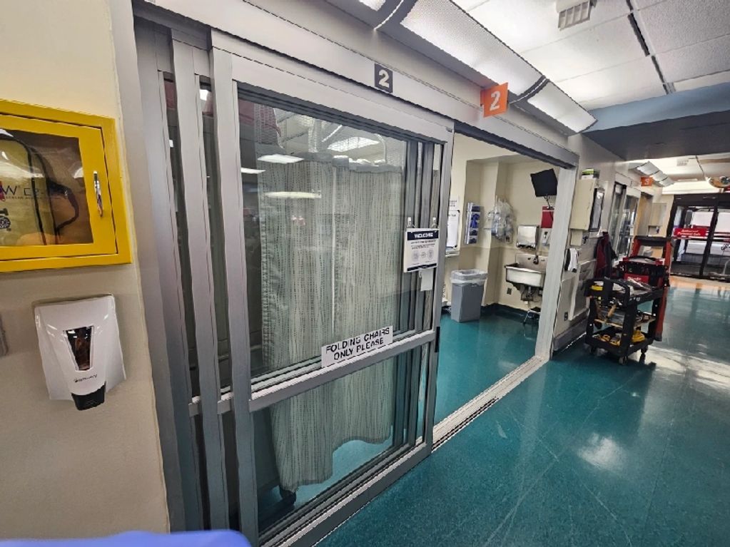 Hospital room with sliding door numbered 2 and medical equipment.
