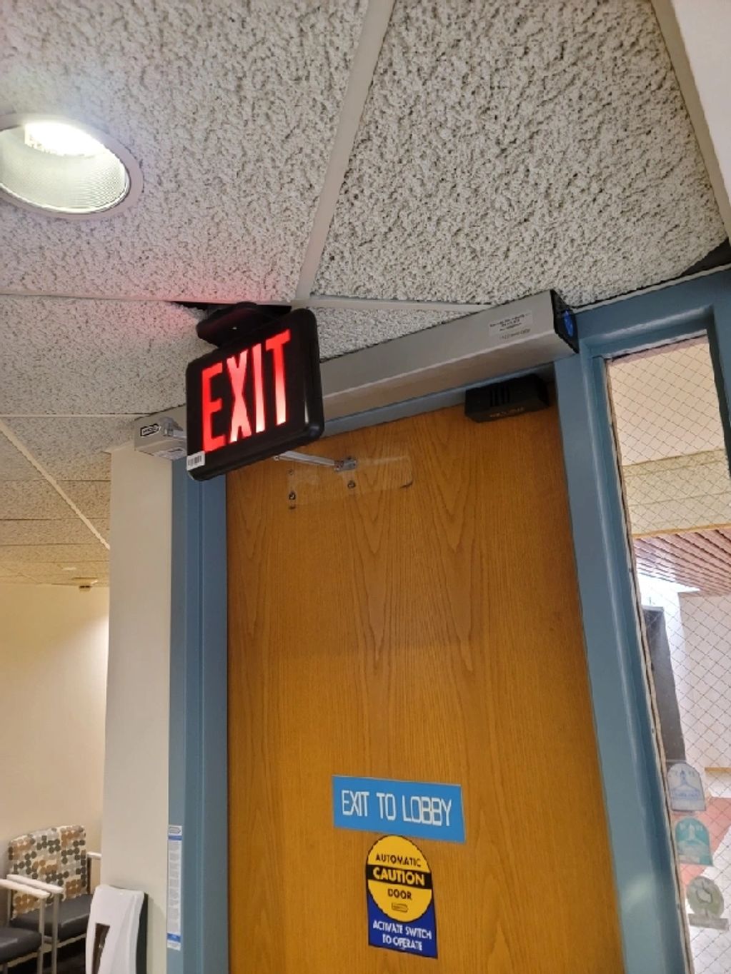 Lit EXIT sign above door marked EXIT TO LOBBY.