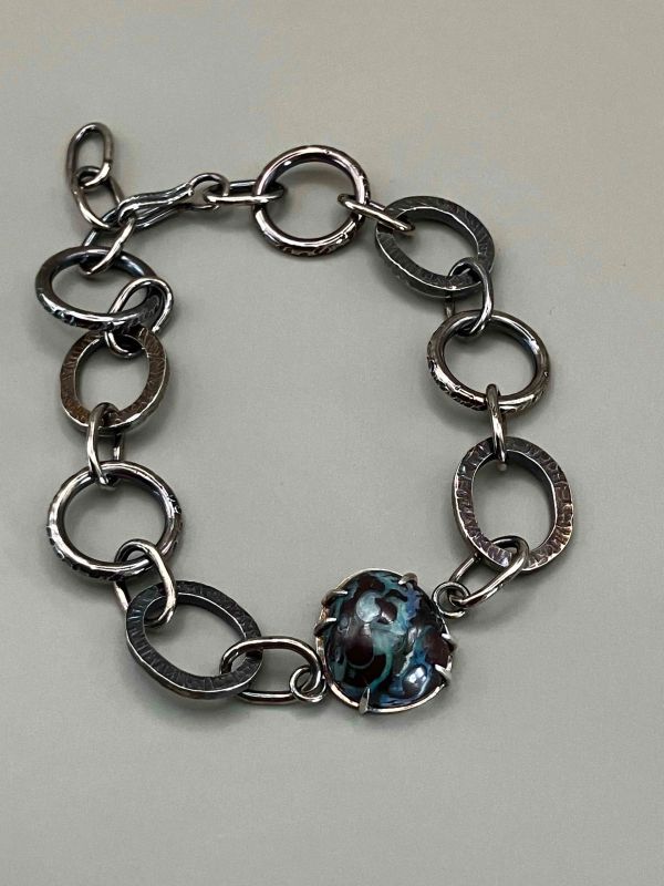 Silver chain bracelet with a blue and brown enamel centerpiece.