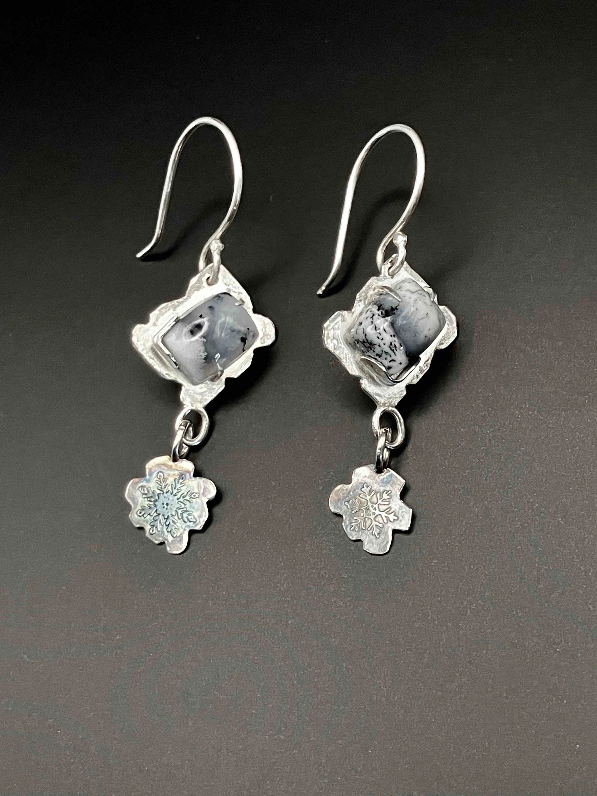 Silver earrings with stone and snowflake charms.