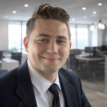 Smiling man in business attire in a modern office.