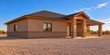 A modern single-story house in a desert setting.