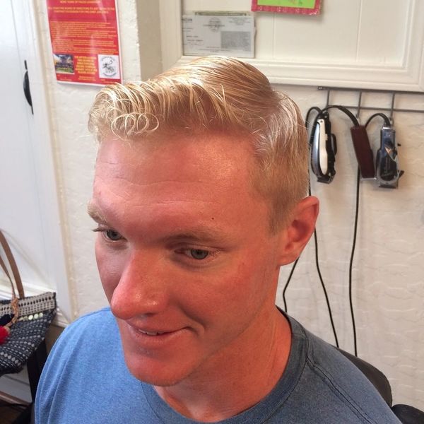 Smiling man with a neat, slicked-back blonde hairstyle.