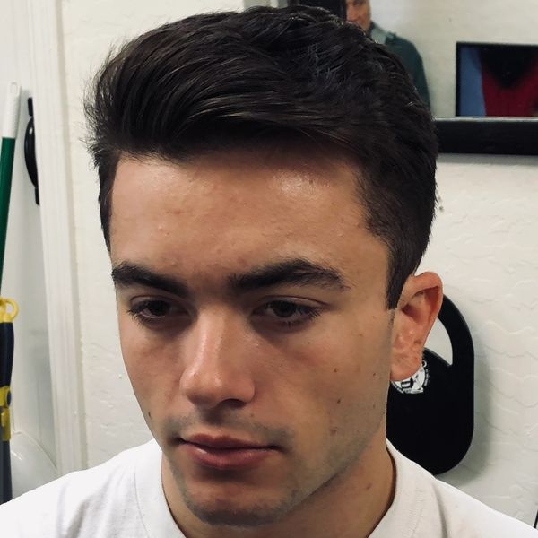 Young man with neatly styled hair wearing a white shirt.