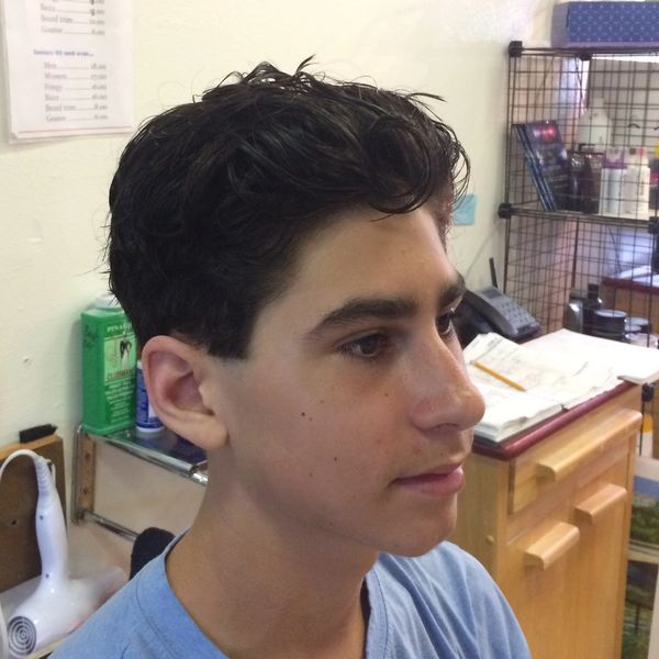 Young man with fresh haircut in a barbershop.