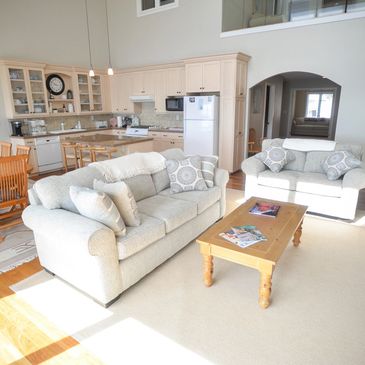 Bright living room with cream sofas and wooden coffee table.