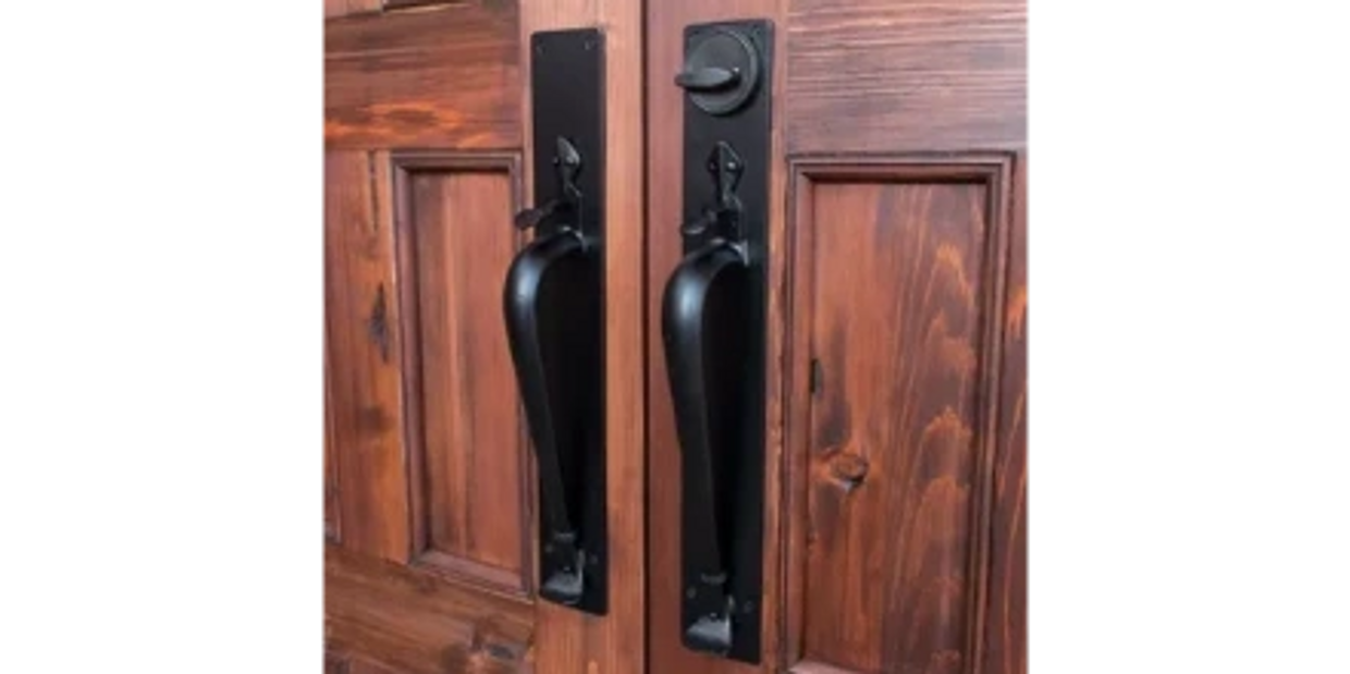 Antique black door handles on wooden double doors.