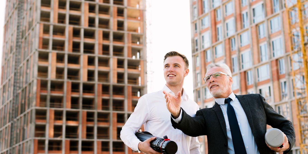 Two architects discussing a building project at a construction site.
