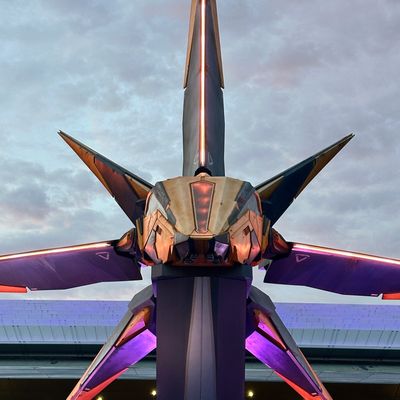 Futuristic sculpture with sharp, angular design and glowing purple lights.