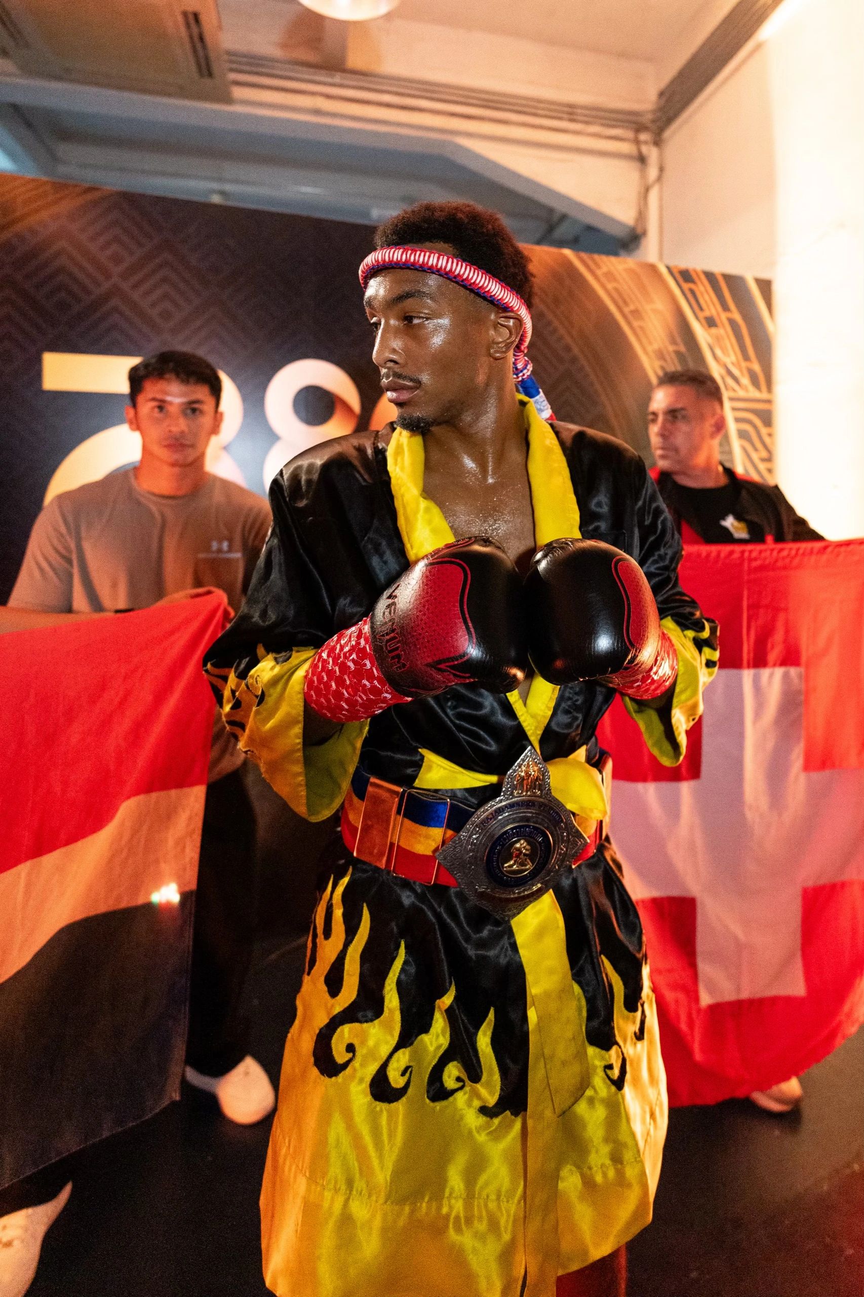 Boxer in a vibrant robe and gloves with a championship belt, preparing for a match.