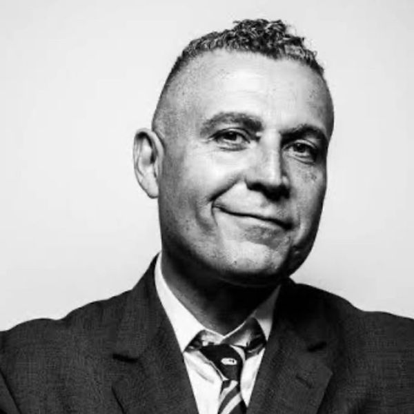 Black and white portrait of a confident man in a suit and tie.