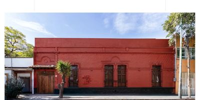 Red exterior of Museo Casa Kahlo with clear blue sky.