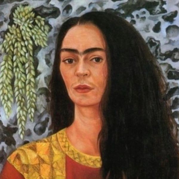 Portrait of a woman with long black hair and a yellow patterned dress.