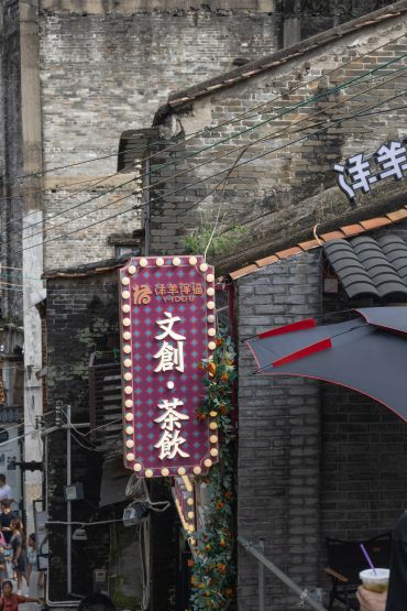 Illuminated traditional signboard on a brick building.