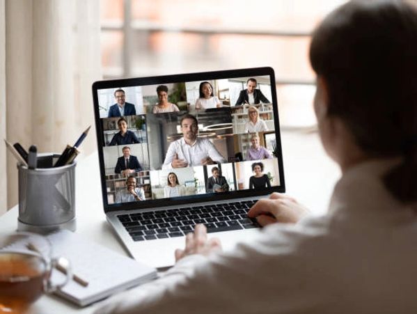 Person attending a virtual meeting on a laptop with multiple participants.