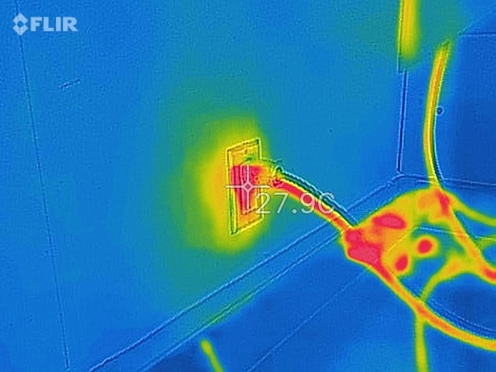 Thermal image showing a power outlet with a plugged-in cable.
