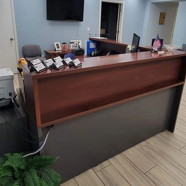 Spotless office space with brown and grey desk and light tile floors just cleaned by professionals