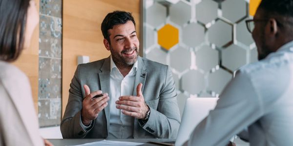 A man in a suit explaining something in a business meeting.