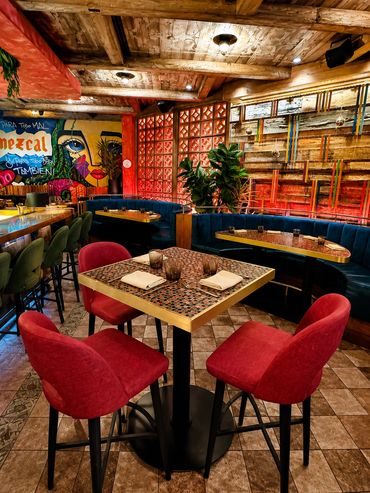 Cozy restaurant interior with red chairs and mosaic table.