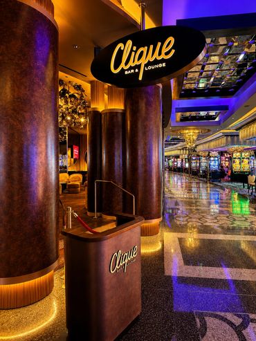 Entrance to Clique Bar &amp; Lounge inside a glamorous casino.