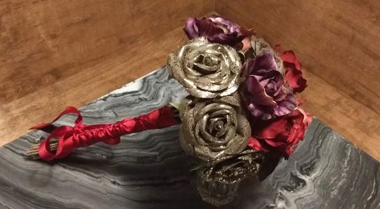 Gold and Brown paper Roses with silk flowers trimmed in Red Satin.