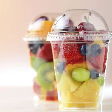 Two plastic cups filled with fresh mixed fruit.